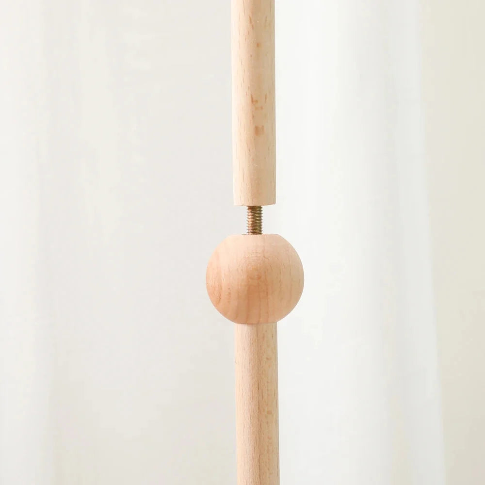 Wooden crib mobile bed bell bracket close-up with screw and round joint
