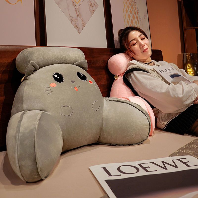 Gray plush animal reading pillow with black eyes, orange nose, and rounded ears