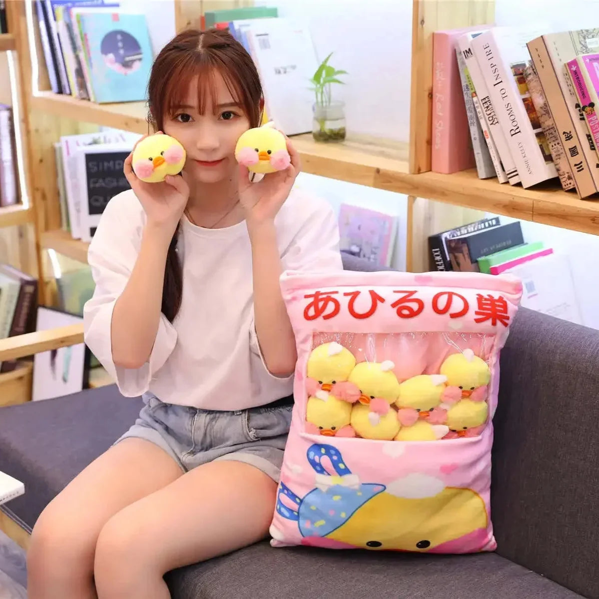 Pink duck plush pillow with duck illustrations and multiple small yellow duck plush toys