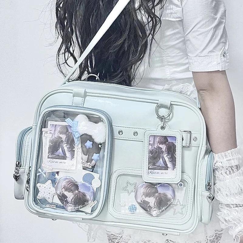 Pastel crossbody bag, light blue, clear front pouch with character-style graphics