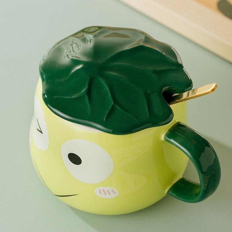 Frog-shaped mug with green lid and spoon, lime green body with eye and nose detail