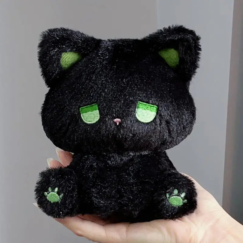 Black plush cat with green sleepy eyes and paw prints, soft stuffed toy