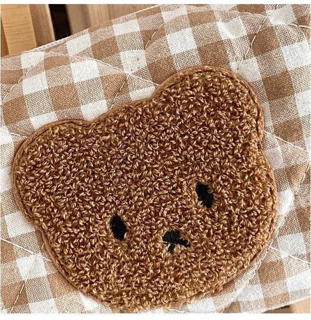 Gingham teddy bear cosmetics bag close-up of textured brown bear face applique