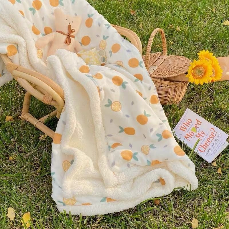 Lamb fleece baby blanket with cream base, fruit pattern, and soft sherpa trim