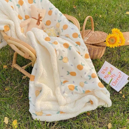 Lamb fleece baby blanket with cream base, fruit pattern, and soft sherpa trim