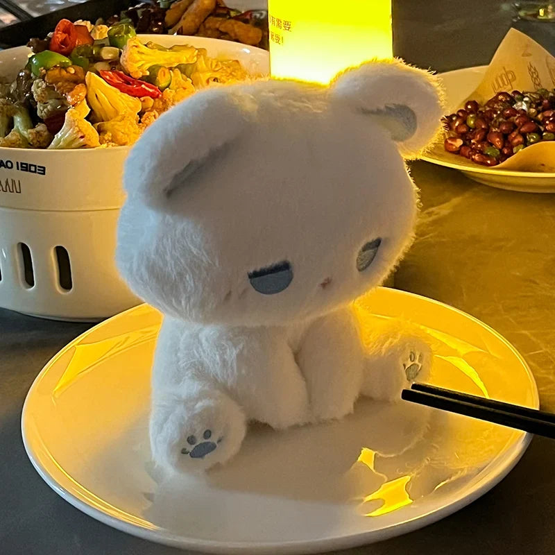 White plush cat with closed eyes and blue paw prints, soft stuffed toy
