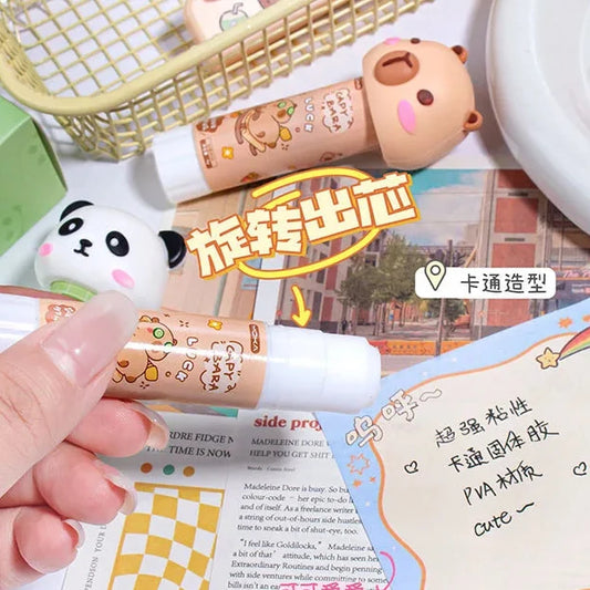 Capybara PVA glue stick held in hand, capped tube with character label