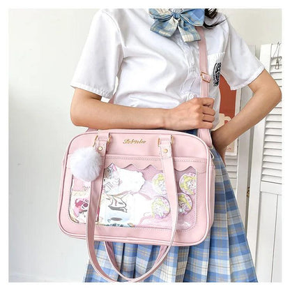 Pink Ita messenger bag with scalloped top, character collage window, pom-pom charm