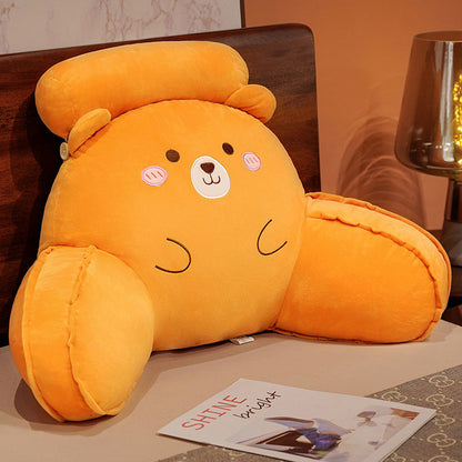 Orange plush animal reading pillow with round cheeks and closed-eye smile