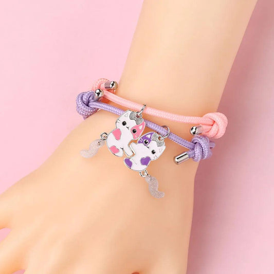 Bracelets on wrist: pink and purple braided bands with cat charms and silver end beads