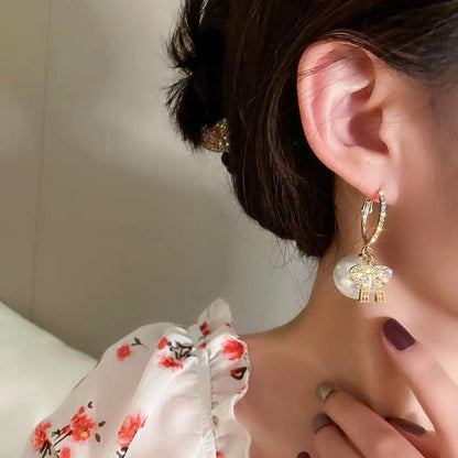 Gold hoop earrings with dangling charm and small square crystal accents