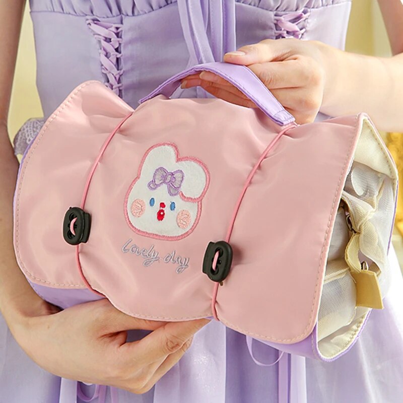Pink roll-up travel makeup bag with cute bear patch and four zip compartments