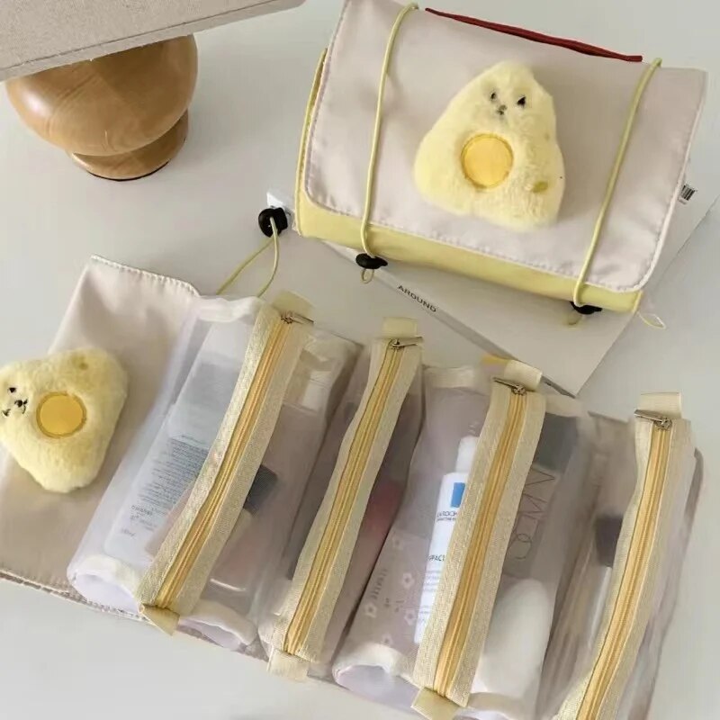 Roll-up makeup bag with chick face patch and four zip pouches, yellow-trimmed white fabric