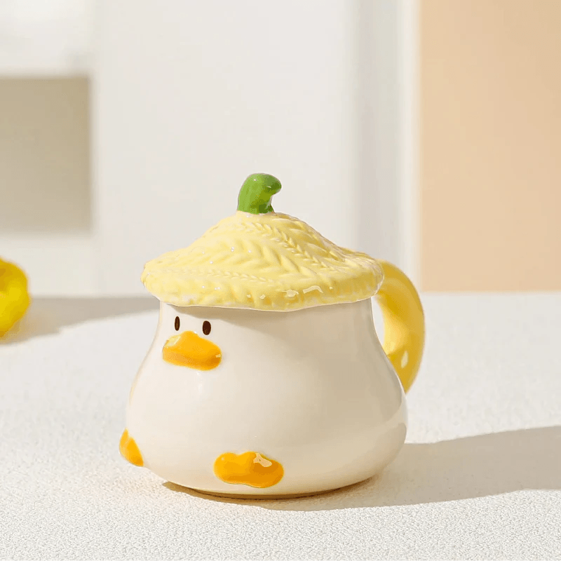 Duck-shaped ceramic mug with green textured lid, orange beak face, and side handle