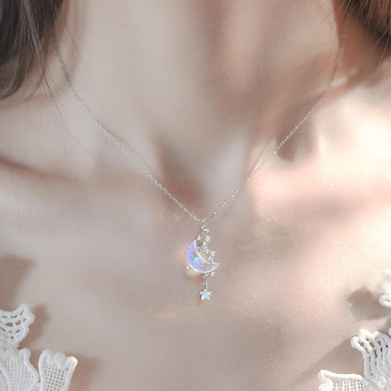 Moon pendant necklace with blue glazed crescent, star charm drop, and crystal accents