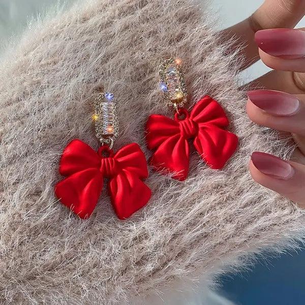 Red satin bow earrings with gold rhinestone dangling bars and hooks