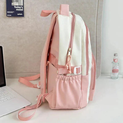 Pink school backpack side view with top handle, front straps, and zip compartments