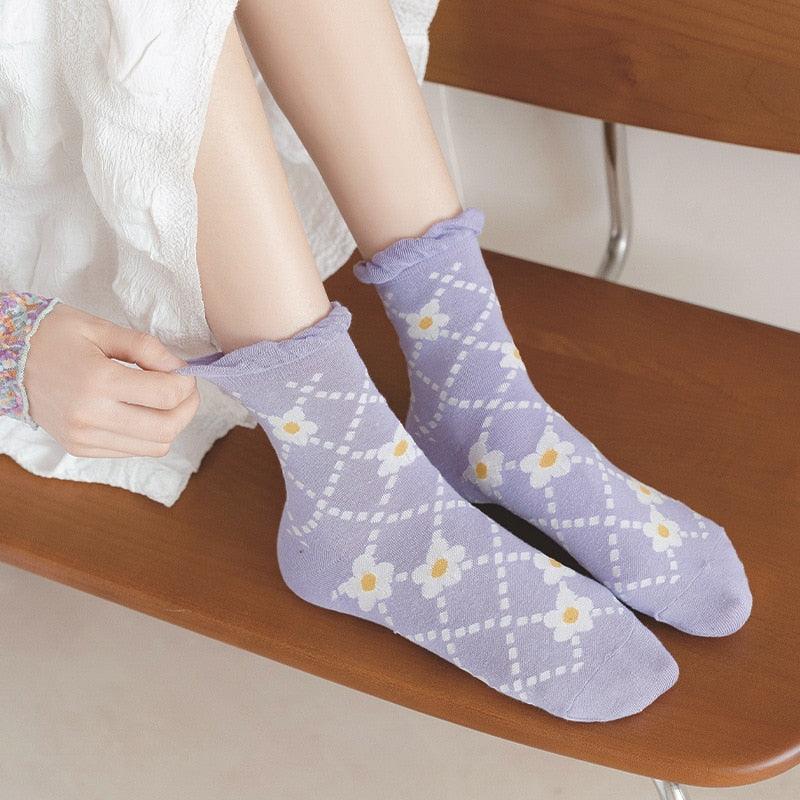 Lavender argyle flower socks with yellow blooms, worn with casual shoes