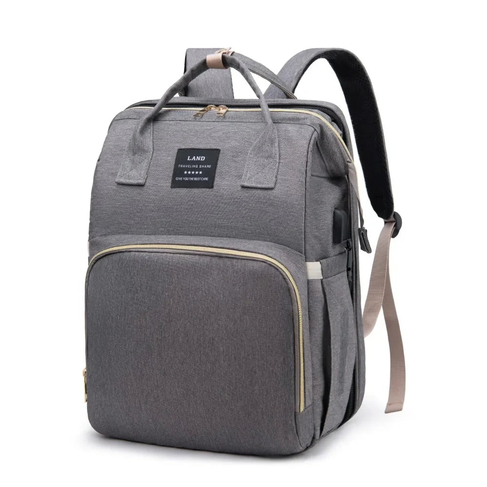 Gray diaper backpack with top handle, front panel pocket, and adjustable shoulder strap