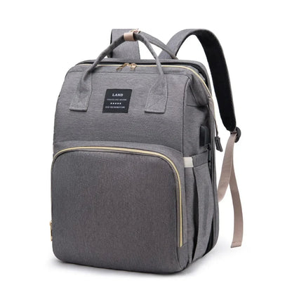 Gray diaper backpack with top handle, front panel pocket, and adjustable shoulder strap