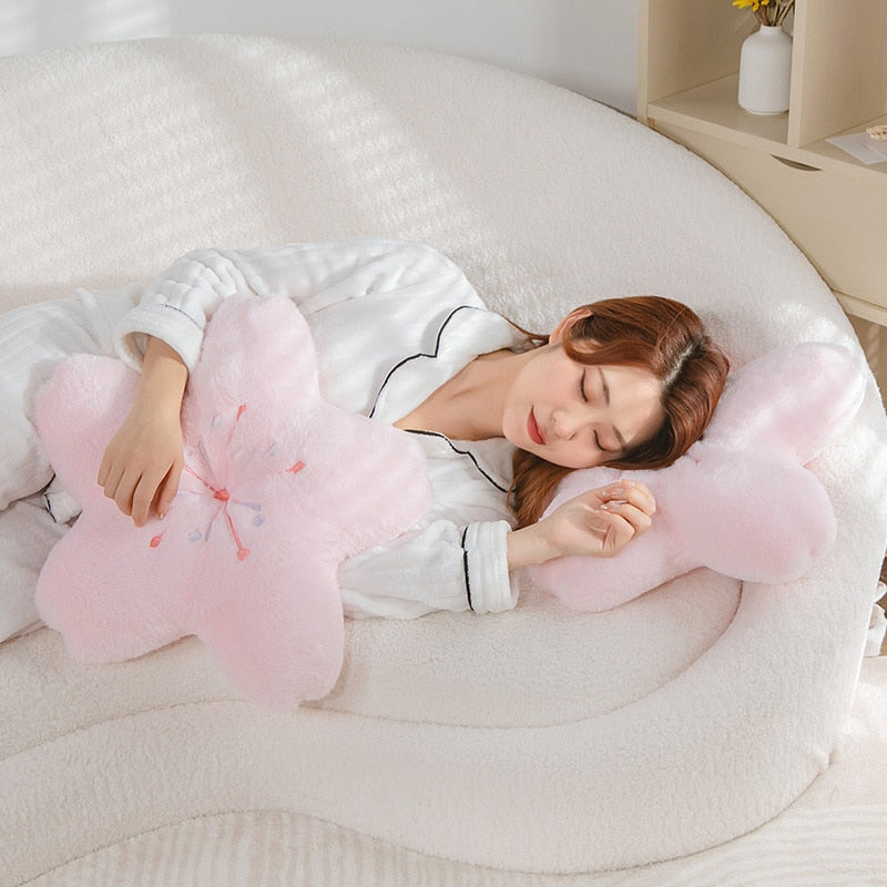 Pink cherry blossom plush pillow set, two flower-shaped cushions on a bed