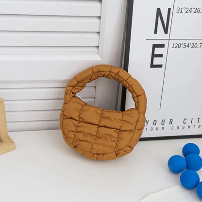 Quilted puffer circle mini bag with top handle, tan padded nylon.