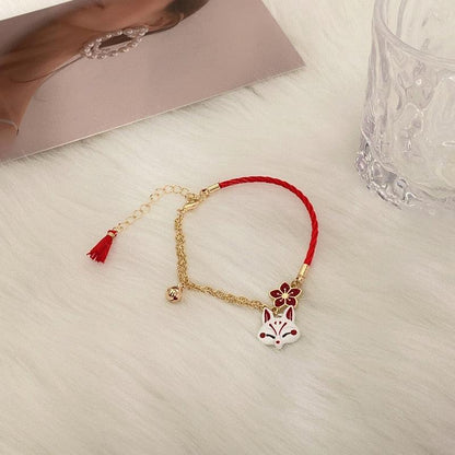 Red and gold fox charm bracelet with tassel, flower charm, and fox head centerpiece