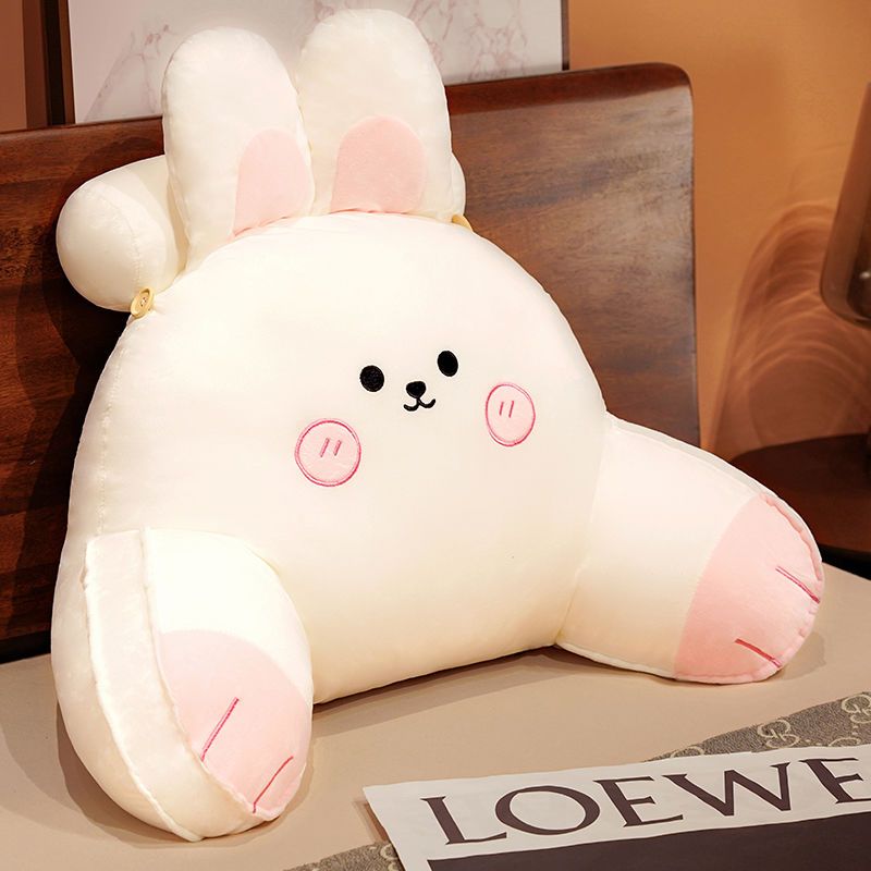 White plush reading pillow shaped like a bunny with pink inner ears