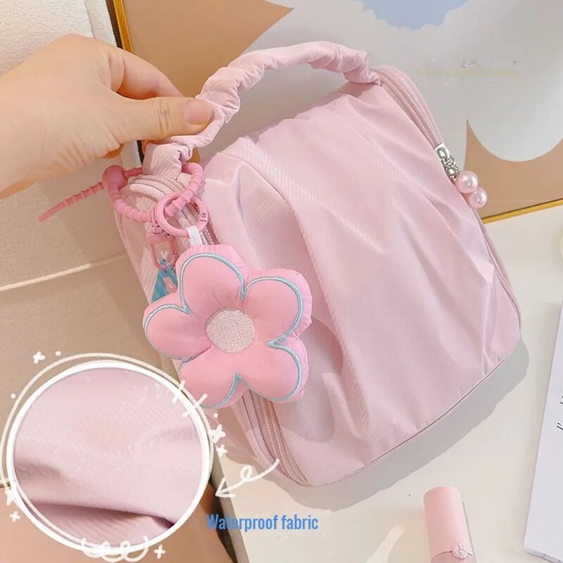 Pink hanging makeup bag with flower-shaped pendant and ruffled top handle