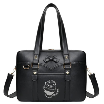 Black faux-leather messenger bag with bow emblem, star accents, and crossbody strap