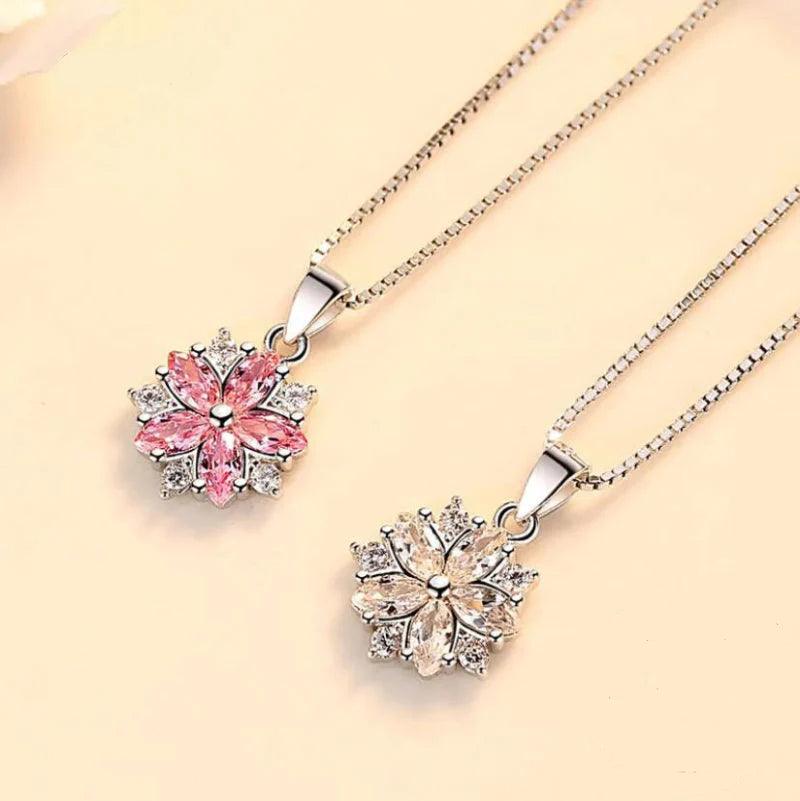Two silver-tone cherry blossom necklaces with pink flower pendants on chains