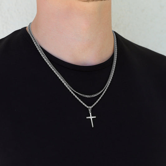 Silver cross necklace set with two layered chains and small cross pendants at chest