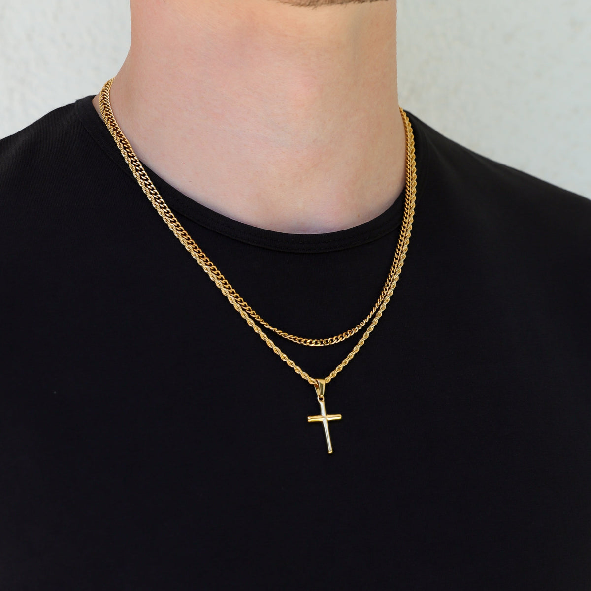 Gold small cross necklace set on neck with two layered chains and cross pendant