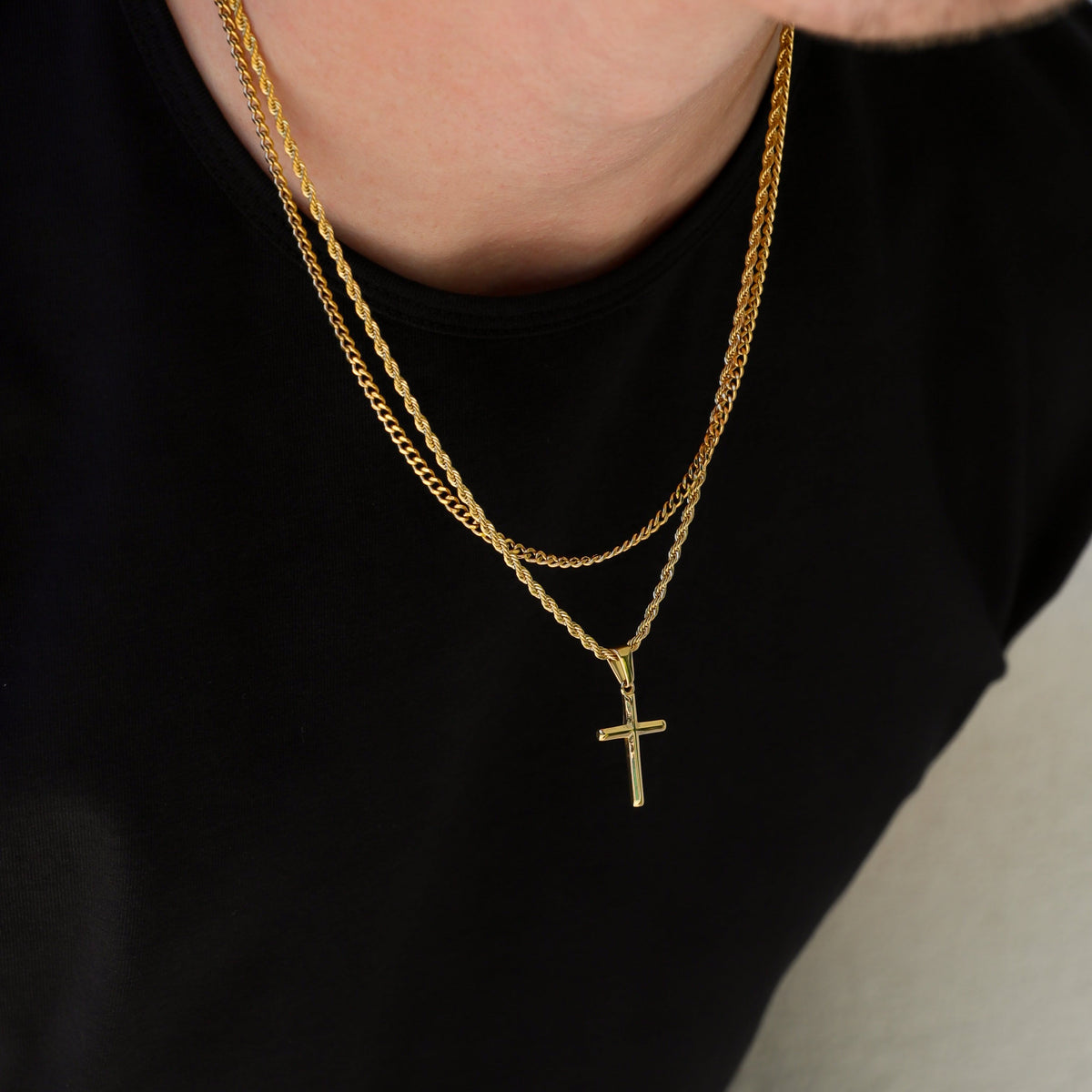 Close-up of gold small cross necklace set with two layered chains and cross pendant