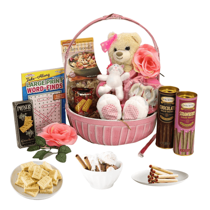 Pink gift basket with Care Bear plush, rose accents, and assorted snacks