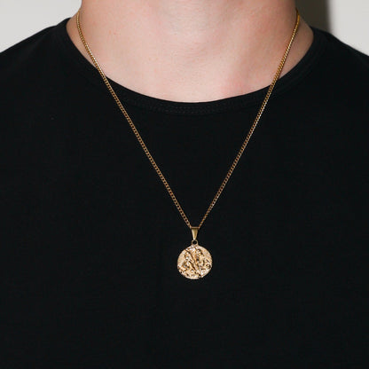 Gold coin pendant necklace worn on chest over black crewneck shirt