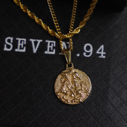 Close-up gold coin pendant with St. George relief and small top bail