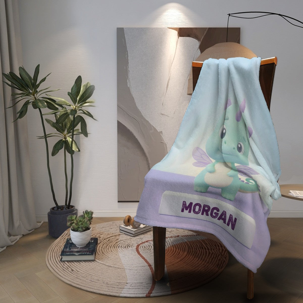 Light blue flannel throw blanket with dragon illustration and purple “MORGAN” stripe
