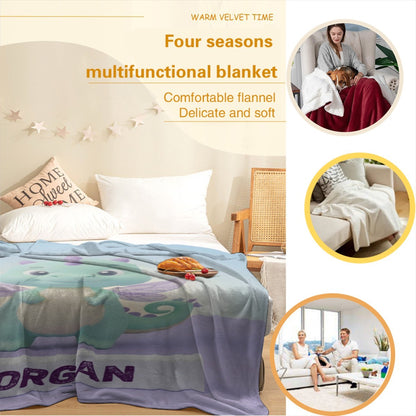 Flannel blanket with dragon graphic and purple “MORGAN” label in a bed setting
