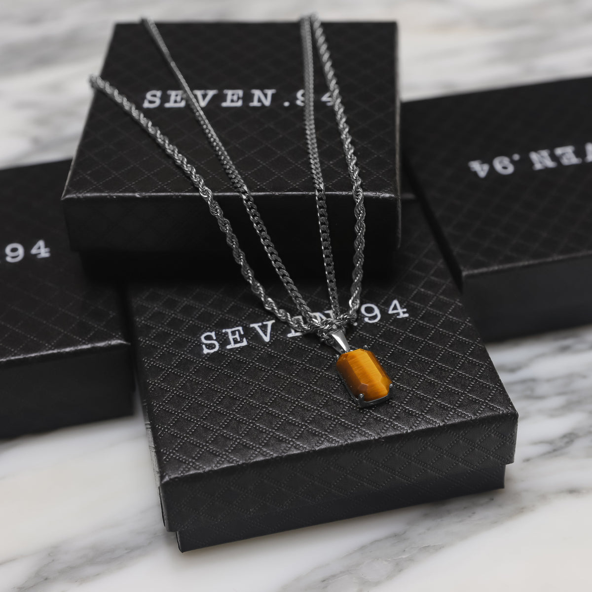 Silver tiger eye pendant necklace set on black gift boxes, layered chains with rectangular charm
