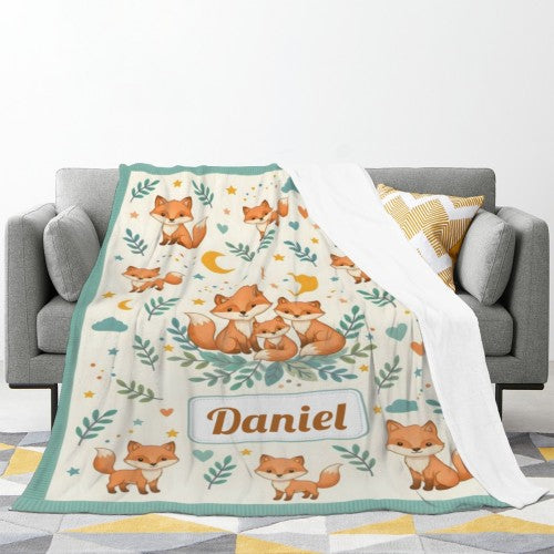 Teal-trim fox blanket covering sofa; woodland fox print with name Daniel centered.