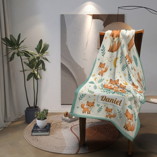 Fox blanket draped over chair with teal border; name Daniel in a label-style patch.