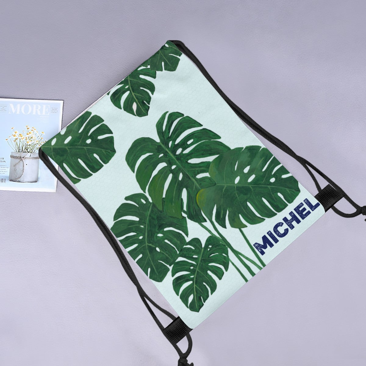 Monstera leaf drawstring tote with MICHEL name printed on light aqua fabric