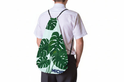 Monstera leaf drawstring backpack worn by child, MICHEL name on front