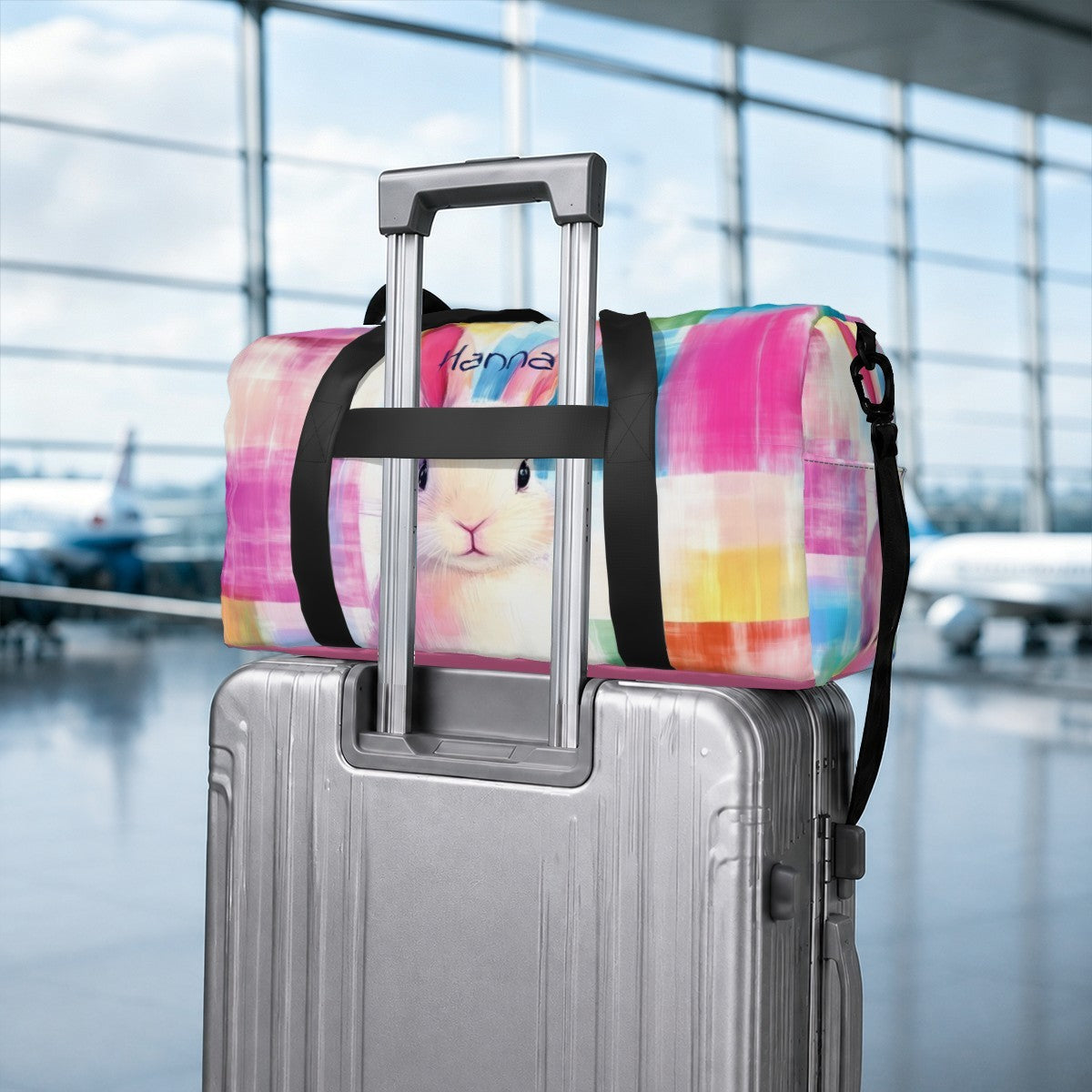 Colorful rabbit print duffel bag with black straps, mounted on suitcase handle