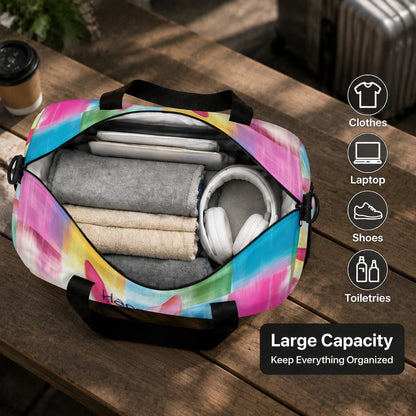 Open duffel bag with colorful rabbit print, showing folded clothes and headphones