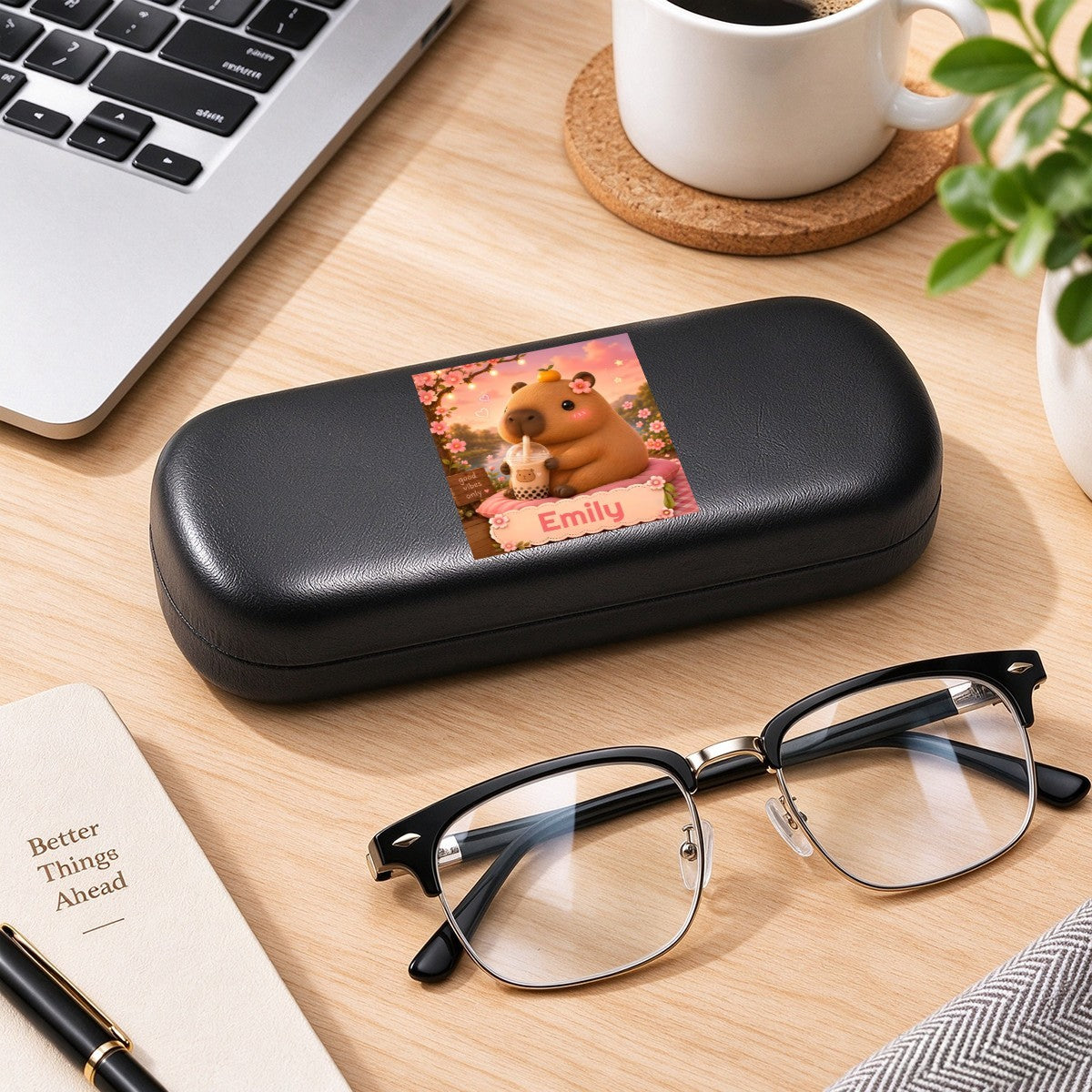 Black eyeglasses case with capybara photo insert, placed on a desk with glasses.