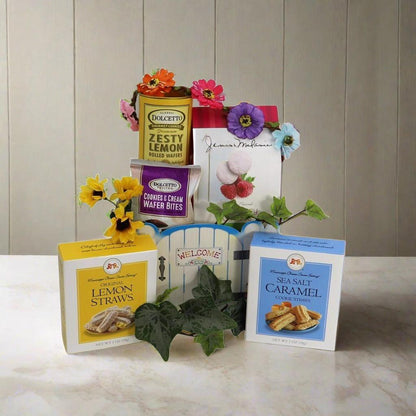 Welcome Home gift basket with colorful flowers, zesty lemon rolls and caramel wafers