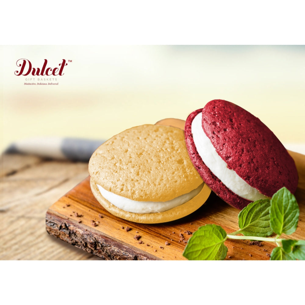 Raspberry macarons with white filling and round cookies on a wooden board