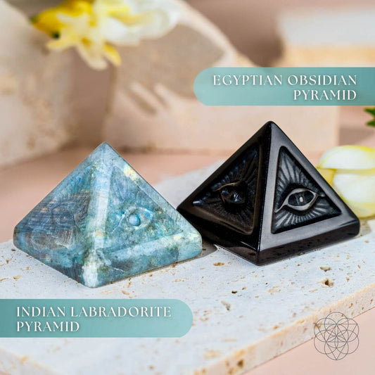 Labradorite and obsidian pyramid crystals, both carved with an all-seeing eye symbol